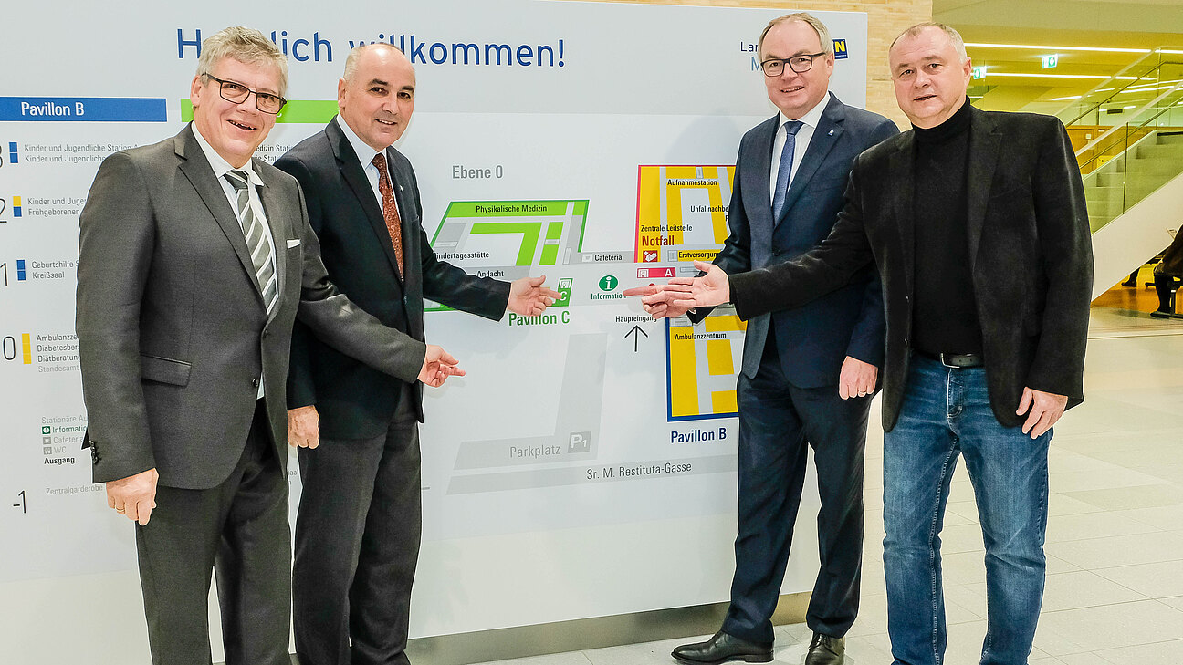 Vier Herren zeigen auf den Stationenplan des Mödlinger Krankenhauses.