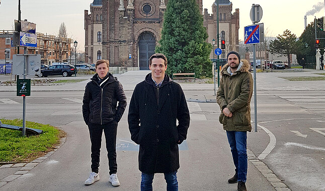 Drei Männer stehen auf dem Gehsteig gegenüber der Waisenhauskirche.